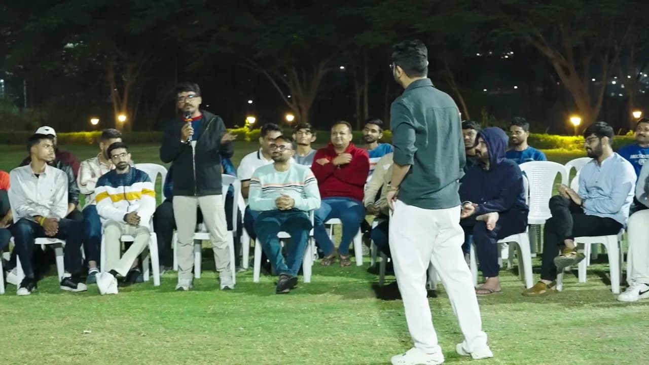 Traders sitting outdoors at night sharing their experiences