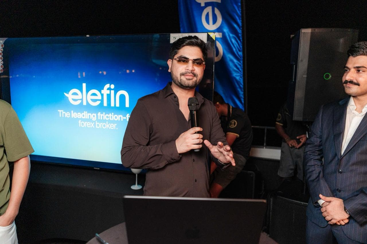 Prasad speaking with a microphone at a trading event